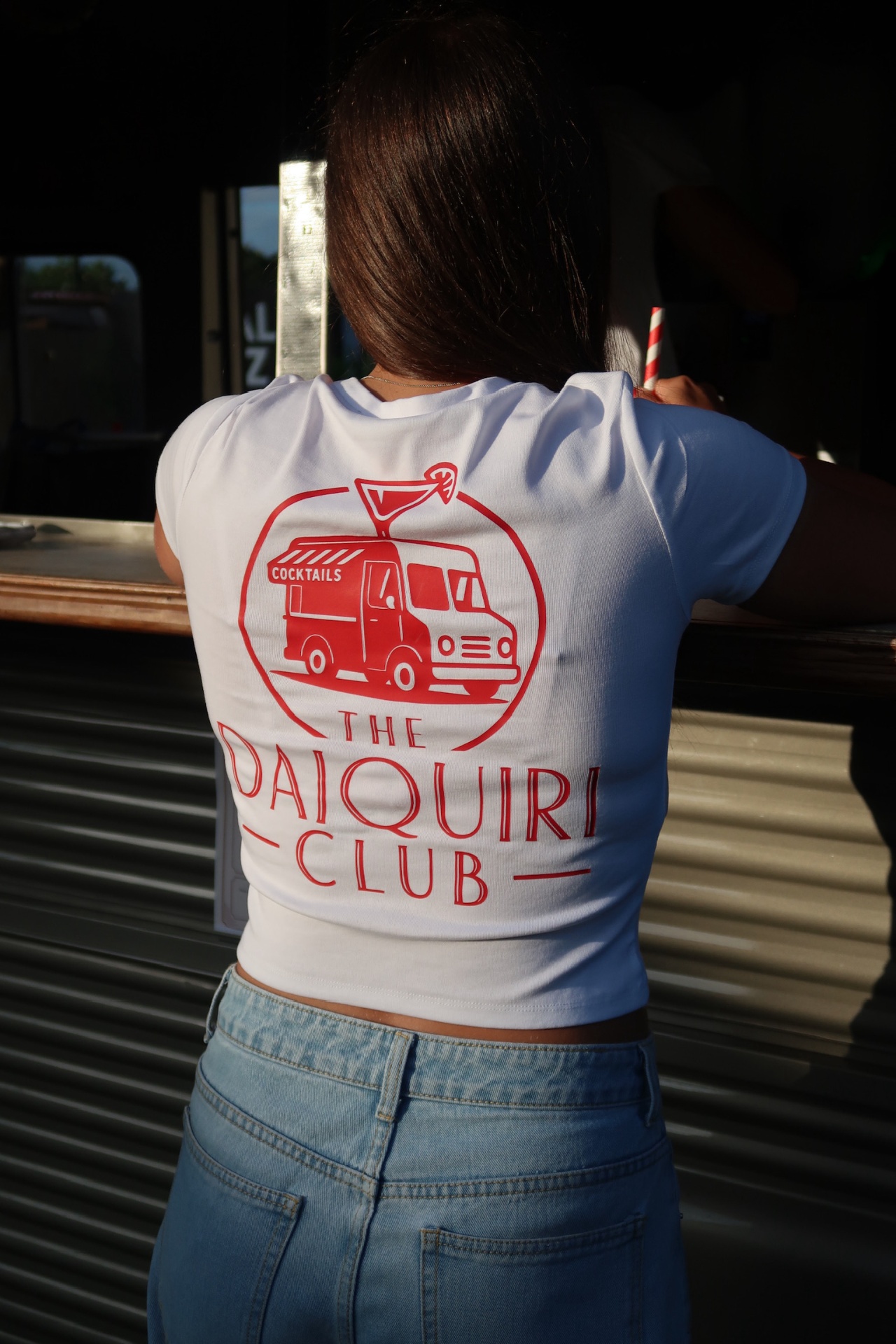Woman wearing a white Daiquiri Club tee at the van bar