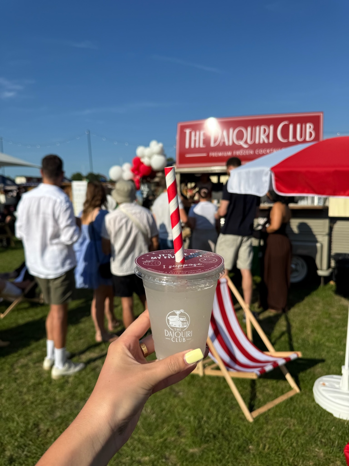 Frozen daiquiri in hand with red and white deckchair and van in the background