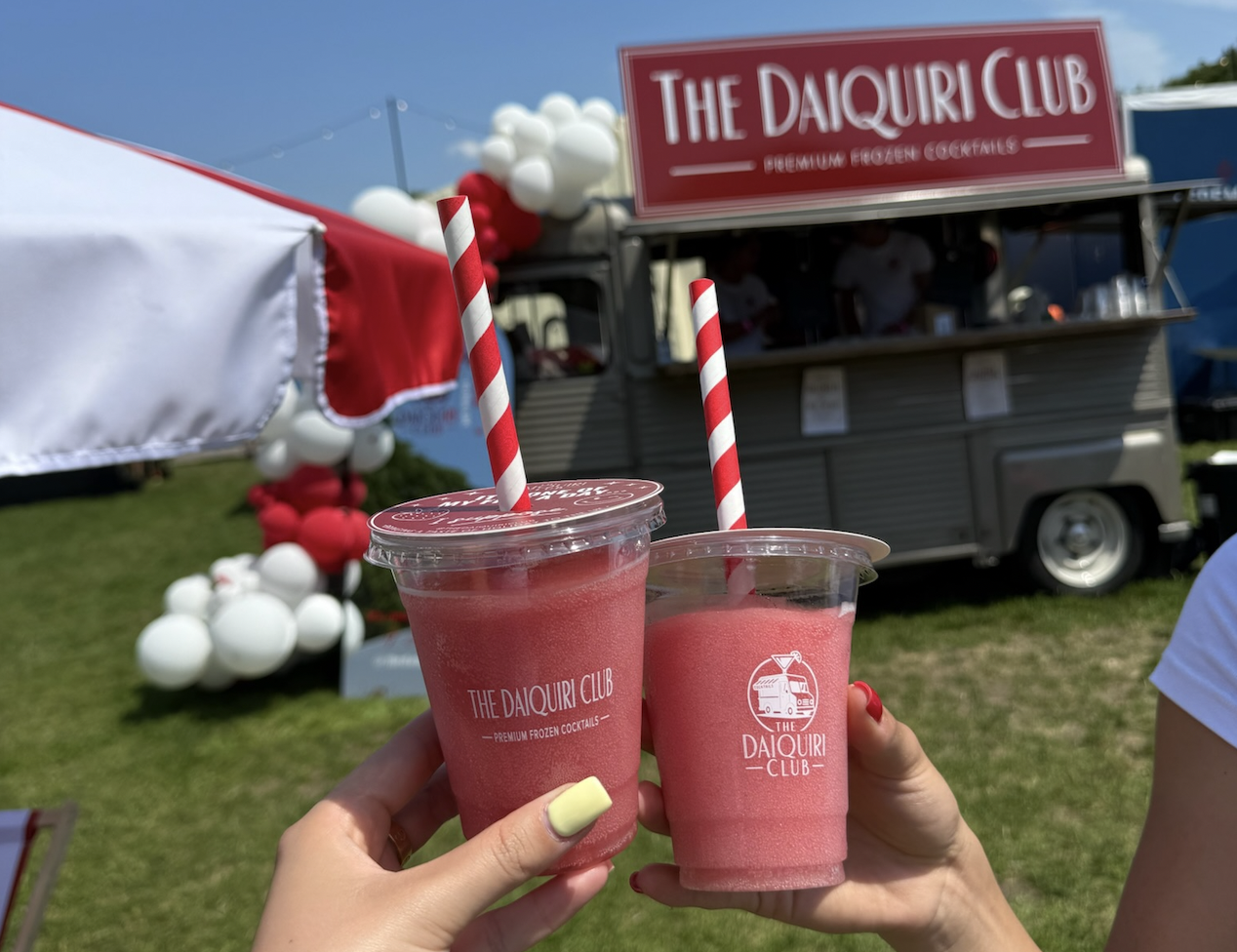 Two strawberry daiquiris cheers in front of The Daiquiri Club van
